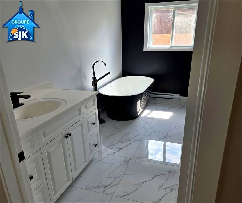 Même salle de bain après : vanité blanche, baignoire autoportante noire, céramique