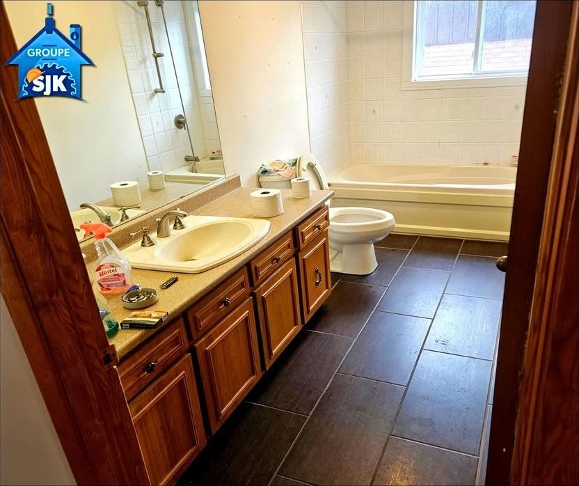 Salle de bain avant : vanité en bois, bain encastré, plancher foncé